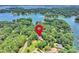 Scenic aerial view of a house nestled amongst lush trees on a lake, indicated by a red pin at 19900 Stough Farm Rd, Cornelius, NC 28031