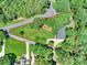 A bird's eye view of a property with a red boundary line, surrounded by lush greenery and trees at 19900 Stough Farm Rd, Cornelius, NC 28031