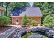 Back view of brick detached garage, pond, and lovely landscaping at 19900 Stough Farm Rd, Cornelius, NC 28031