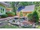 Picturesque view of the garage, the back of the house, lush landscaping, and a rock pond at 19900 Stough Farm Rd, Cornelius, NC 28031