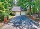Brick two-car detached garage with a spacious driveway, framed by lush trees and greenery at 19900 Stough Farm Rd, Cornelius, NC 28031