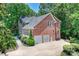 Side view of a beautiful brick home with a well-manicured yard, driveway, and a two-car garage at 19900 Stough Farm Rd, Cornelius, NC 28031