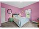 Comfortable bedroom with soft, pink walls, a floral bedspread, and a large window with side views, inviting relaxation at 307 Nc Hwy 49 S Hwy, Richfield, NC 28137