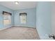 Simple, light-blue bedroom with carpeted floors and two windows covered with blinds and dark, decorative valances at 307 Nc Hwy 49 S Hwy, Richfield, NC 28137