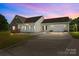 Charming home with stone accents, covered porch, and an attached two-car garage at dusk at 307 Nc Hwy 49 S Hwy, Richfield, NC 28137