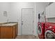 Efficient laundry room featuring a utility sink, cabinets, and a modern, red front-load washer and dryer set at 307 Nc Hwy 49 S Hwy, Richfield, NC 28137