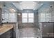 Modern bathroom featuring a spacious shower with double shower heads, gray tiling, and a pebble floor at 329 Wave Crest Dr, Tega Cay, SC 29708