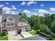 Exterior view of a townhome showcasing its two-car garage, stone facade, and manicured lawn at 329 Wave Crest Dr, Tega Cay, SC 29708