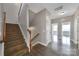 Foyer with hardwood floors, wood stairs and white railing, with entryway to a bedroom at 329 Wave Crest Dr, Tega Cay, SC 29708