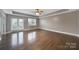 Spacious bedroom with tray ceilings, ceiling fan, hardwood floors and a double door to a balcony at 329 Wave Crest Dr, Tega Cay, SC 29708
