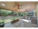 Covered outdoor kitchen area featuring a stone facade, built-in grill, and ceiling fans at 329 Wave Crest Dr, Tega Cay, SC 29708