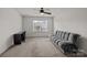 This bedroom features neutral carpet, a ceiling fan, and a comfortable gray couch at 4022 Perth Rd, Indian Land, SC 29707