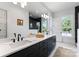 Bright bathroom features a double vanity, large mirror, and window providing plenty of natural light at 419 Solomon St, Charlotte, NC 28216