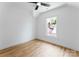 Minimalist bedroom with hardwood floors, a ceiling fan, and a window providing natural light at 419 Solomon St, Charlotte, NC 28216
