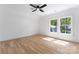 Bright bedroom with hardwood floors, ceiling fan, and large windows overlooking the lush yard at 419 Solomon St, Charlotte, NC 28216