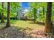 Spacious backyard featuring lush greenery, mature trees, and a deck attached to the home at 4203 Flint Dr, Lancaster, SC 29720