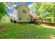 View of the backyard featuring a large green lawn and a wooden deck with railing at 4203 Flint Dr, Lancaster, SC 29720