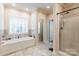 Bright bathroom with tub, separate shower, tile flooring, and large window at 4203 Flint Dr, Lancaster, SC 29720