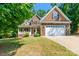 Inviting two-story home showcasing a blend of stone and wood siding, complemented by a well-manicured lawn at 4203 Flint Dr, Lancaster, SC 29720