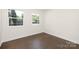 Empty bedroom featuring hardwood floors and natural light from the surrounding trees at 4219 Tipperary Pl, Charlotte, NC 28215