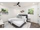 Bedroom with a gray bed frame, soft white bedding, and natural light streaming through two windows at 4219 Tipperary Pl, Charlotte, NC 28215