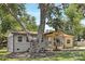 Exterior showcasing gray siding, a covered porch, and mature trees shading the property at 4219 Tipperary Pl, Charlotte, NC 28215