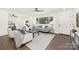 Bright living room with hardwood floors, large windows, and neutral-toned furniture at 4219 Tipperary Pl, Charlotte, NC 28215