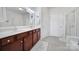 Bathroom featuring double sinks with cherry cabinets, granite counters, tile floors, and glass shower at 44424 Oriole Dr # 200, Indian Land, SC 29707
