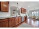 Open kitchen view of cherry cabinets, granite counters, stainless appliances, hardwood floors, and a dining area at 44424 Oriole Dr # 200, Indian Land, SC 29707
