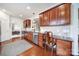 View of the kitchen with cherry cabinets, stainless appliances, hardwood floors, and a view to the dining and living area at 44424 Oriole Dr # 200, Indian Land, SC 29707