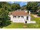 View of the back of a well-maintained home featuring a backyard with lush green grass and mature trees at 509 8Th Avenue Ext, Cramerton, NC 28032