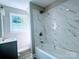 Bathroom featuring modern vanity and tub with white marble tile and rainfall shower head at 509 8Th Avenue Ext, Cramerton, NC 28032