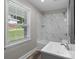 Bathroom with tub/shower combo, marble tile, stylish vanity, and natural light from the window at 509 8Th Avenue Ext, Cramerton, NC 28032