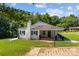 Charming home exterior featuring a white brick facade, covered porch, and landscaped front yard at 509 8Th Avenue Ext, Cramerton, NC 28032