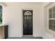 Close-up of the inviting black front door with decorative window, set in a white brick facade at 509 8Th Avenue Ext, Cramerton, NC 28032