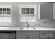 Stylish kitchen with sleek sink, stainless steel dishwasher, white marbled backsplash, and two windows at 509 8Th Avenue Ext, Cramerton, NC 28032