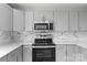 Modern kitchen with stainless steel appliances, oven range, and marble-styled backsplash at 509 8Th Avenue Ext, Cramerton, NC 28032