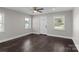 Bright living room with ample natural light, three windows, dark wood floors, and white door at 509 8Th Avenue Ext, Cramerton, NC 28032