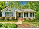 Charming home featuring a welcoming front porch, complemented by tasteful landscaping and an American flag at 666 Tryon Pl, Gastonia, NC 28054