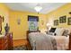 Bright bedroom with yellow walls, hardwood floors, and decoratively adorned with unique wall hangings at 701 4Th Ne Ave, Conover, NC 28613