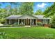 Charming single-story brick home featuring a well-manicured lawn, blooming hydrangeas, and a welcoming front porch at 701 4Th Ne Ave, Conover, NC 28613