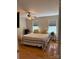 Inviting bedroom featuring hardwood floors, bright windows, and a charming ceiling fan at 729 Victoria Ln, Hickory, NC 28601