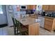 An eat-in kitchen with tile floors, wood cabinets, a granite counter island and white appliances at 729 Victoria Ln, Hickory, NC 28601