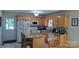 An eat-in kitchen with tile floors, wood cabinets, a granite counter island and white appliances at 729 Victoria Ln, Hickory, NC 28601