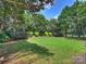 Lush backyard with green lawn, mature trees, and manicured shrubs at 901 Deercross Ln, Waxhaw, NC 28173
