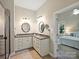 Primary bathroom featuring a double vanity, framed mirrors, and shower with a glass enclosure at 901 Deercross Ln, Waxhaw, NC 28173