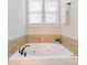 Bathroom with a large tub and window with blinds at 901 Deercross Ln, Waxhaw, NC 28173