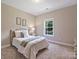 Comfortable bedroom with soft carpet, white bedding, and natural light from the window at 901 Deercross Ln, Waxhaw, NC 28173