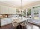 Dining area with white table and chairs, wooden floors, white cabinets and access to a deck area at 901 Deercross Ln, Waxhaw, NC 28173