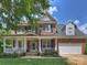Charming two-story brick home featuring a welcoming front porch and well-maintained landscaping with flowering plants at 901 Deercross Ln, Waxhaw, NC 28173